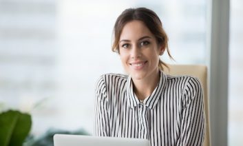 Close up portrait of smiling beautiful millennial businesswoman or CEO looking at camera, happy female boss posing making headshot picture for company photoshoot, confident successful woman at work